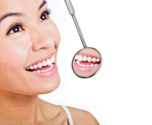 Healthy woman teeth and a dentist mouth mirror